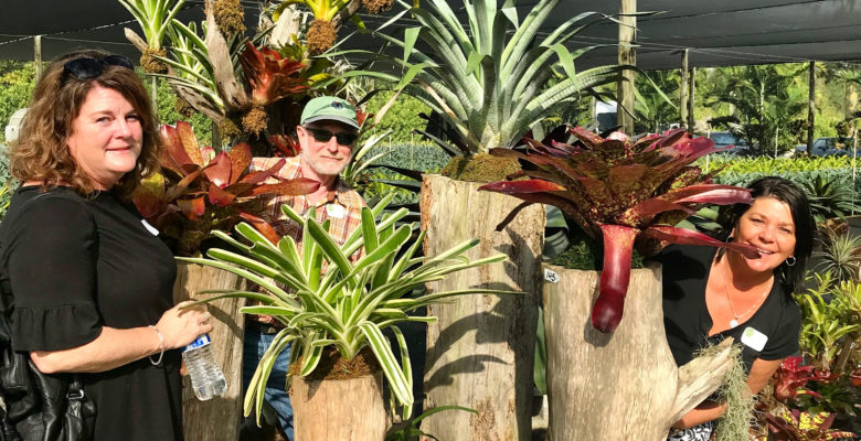 Participants smiling among tropical plants in Miami at a gathering